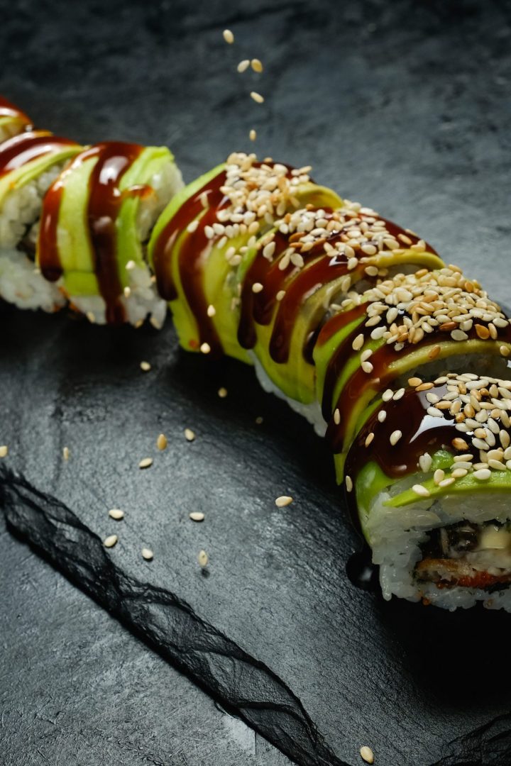 green-dragon-avocado-sushi-rolls-dark-background-with-sesame-seeds-sprinkled-from-creative-food-photography-art-scaled.jpg